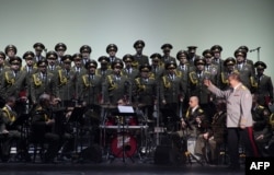 FILE - This photo taken on Oct. 23, 2015 shows the official army choir of the Russian armed forces, also known as the Alexandrov Ensemble, standing while the choir Conductor General Viktor Eliseev (R) arrives onstage at the Palais des Sports in Paris.
