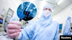 Một khoa học gia trình bày một dĩa bán dẫn silicon tại Viện Công nghệ Thụy Sĩ ở Ecublens, gần Lausanne,