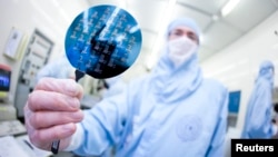 FILE - A scientist presents a silicon wafer.