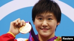 Perenang Tiongkok Ye Shiwen menggengam medali emasnya seusai upacara penyerahan medali untuk para juara renang medley perorangan 400 meter di Olimpiade London 2012 (31/7).