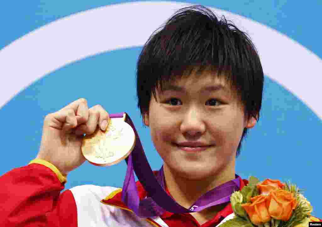 China's Ye Shiwen poses with her gold medal on the podium during the women's 400m individual medley victory ceremony at the London 2012 Olympic Games at the Aquatics Centre July 28, 2012. Ye smashed the world record to win the gold medal on Saturday with 