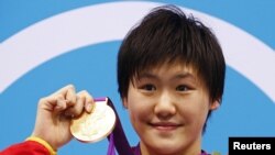 China's Ye Shiwen poses with her gold medal on the podium during the women's 400m individual medley victory ceremony at the London 2012 Olympic Games at the Aquatics Centre July 28, 2012.