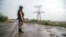 FILE - A Ukrainian serviceman stands near an electricity transmission tower outside the town of Zolote, some 60 km west of Luhansk city, Luhansk region, eastern Ukraine, Aug. 16, 2015. Ukraine's government announced Monday it will cut off power to rebel-held parts of Luhansk region because of millions in unpaid bills.
