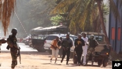 20일 말리 특수부대가 인질극이 벌어진 바마코에서 호텔 밖에서 빠져나온 인질들을 호위하고 있다.