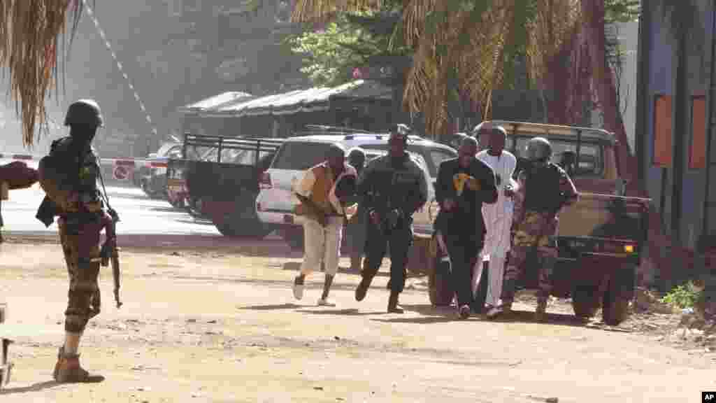 Mutane su na gudu daga hotel din Radisson Blu Hotel na Bamako, Mali, Jumma&#39;a, Nov. 20, 2015.