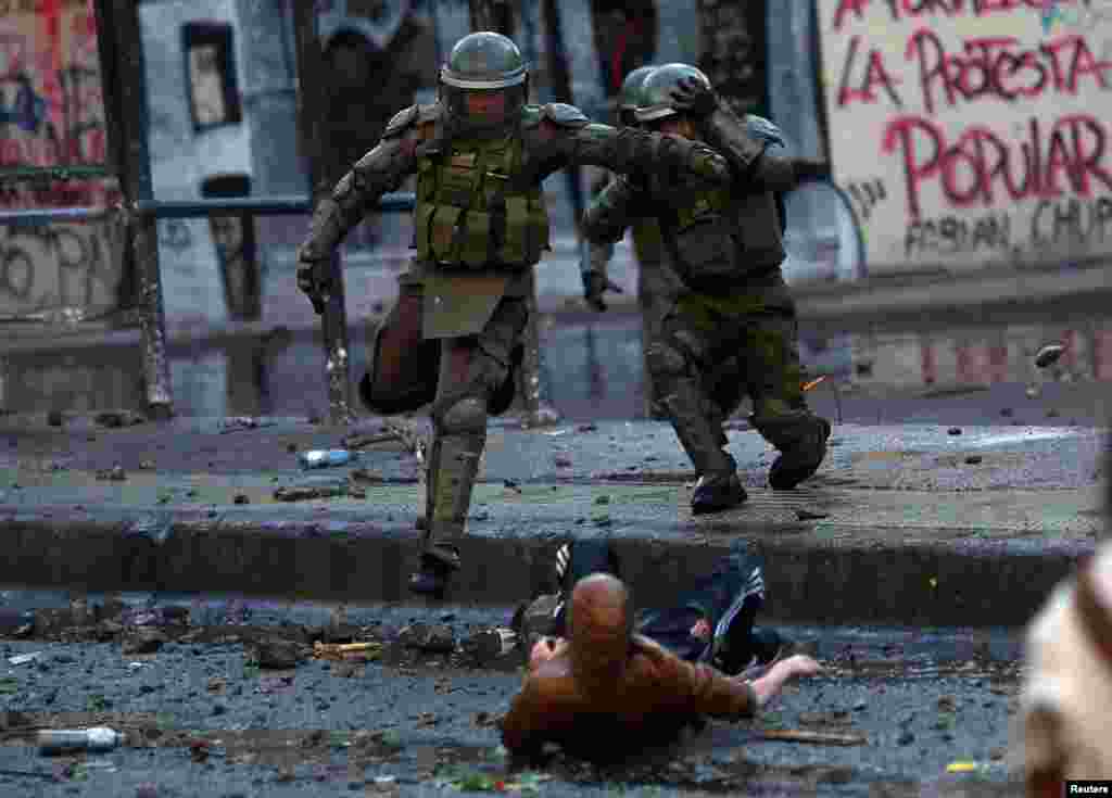 Riot police officers clash with demonstrators during protests against Chile&#39;s government in Santiago, Dec. 14, 2019.