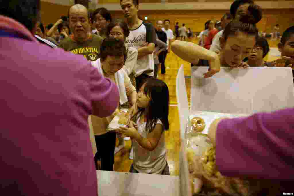 Evacuees from typhoon Etau receive food supplies at Ishige Sports Park, which has become an evacuation center, in Joso, Ibaraki prefecture, Sept. 10, 2015.