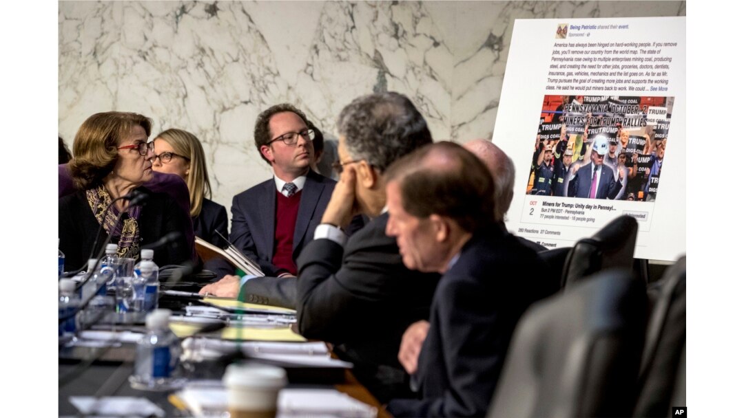 Democratic Sen. Dianne Feinstein, left, and several Senate colleagues look at a poster depicting an example of a misleading internet ad as representatives of Facebook, Twitter and Google testify during hearing on Capitol Hill in Washington, Oct. 31, 2017.
