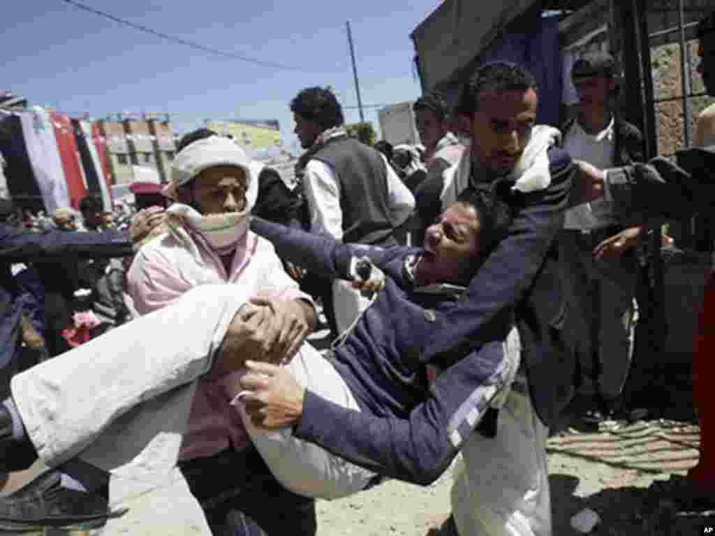 Anti-government protesters carry a protester wounded in October in clashes with security forces. (AP)