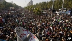 15일 파키스탄 이슬라마바드에서 이틀째 대규모 시위가 열린 가운데, 이슬람 지도자 타히르 울 카드리가 연설을 듣고 있는 시위대.