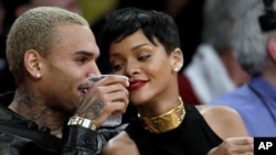 Entertainers Chris Brown, left, and Rihanna attend an NBA basketball game between the Los Angeles Lakers and New York Knicks in Los Angeles, December 25, 2012.