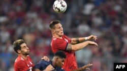 Pemain depan Manchester United, Marcus Rashford (tengah) berebut bola dengan gelandang Munich asal Spanyol, Javi Martinez (kiri) dan bek Niklas Sule, dalam pertandingan persahabatan antara Bayern Munich dan Manchester United di Munich, selatan Jerman, 5 Agustus 2018.
