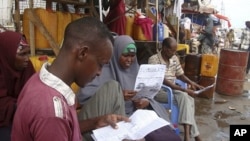 People read local newspapers reporting the death of al-Qaida leader Osama bin Laden, in the streets of Somalia's capital Mogadishu, May 3, 2011