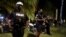 Police officers stand guard as revelers enjoy spring break festivities in Miami Beach, Florida, March 22, 2021.