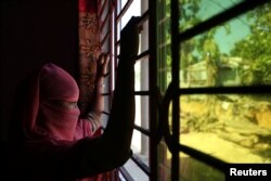 Seorang anak perempuan Rohingya berumur 12 tahun di Bangladesh yang bekerja sebagai pembantu rumah tangga di Bangladesh,memandang keluar jendela di lokasi yang tidak disebutkan, dekat Cox's Bazar, Bangladesh, 8 November 2017.