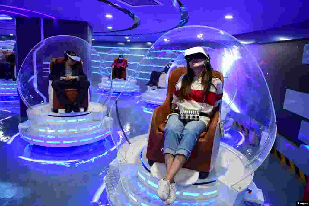 People wearing virtual reality (VR) headsets watch films at a newly opened VR cinema by Er Dong Pictures in Beijing, China, March 27, 2019.
