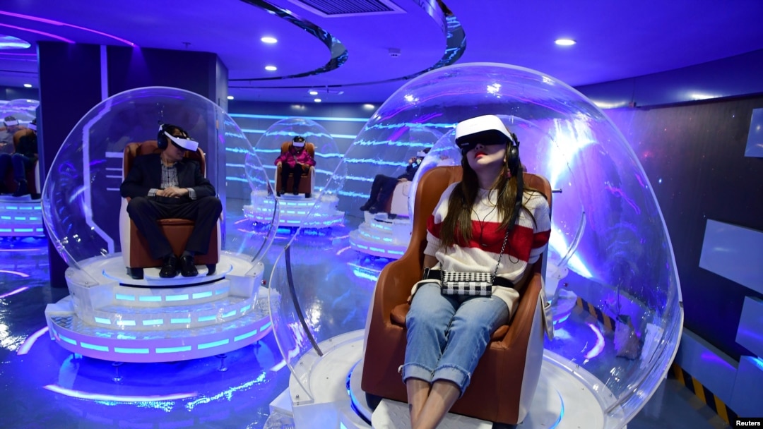 戴着虚拟现实（VR）眼镜的人们在中国北京一家新开放的VR电影院观看电影（资料图， 2019年3月27日）