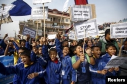 FILE - Nepalese students holding placards take part in a protest to show solidarity against the border blockade in Kathmandu, Nepal, Nov. 27, 2015.