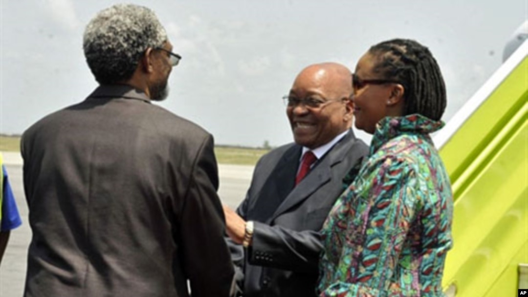 South African president Jacob Zuma (C), flanked by South African ambassador to Ivory Coast Lallie Ntombizodwa (R), shakes hands with African Union representative to Ivory Coast Ambroise Niyonsaba (L) as he arrivesat Abidjan international airport on Februa