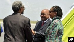 South African president Jacob Zuma (C), flanked by South African ambassador to Ivory Coast Lallie Ntombizodwa (R), shakes hands with African Union representative to Ivory Coast Ambroise Niyonsaba (L) as he arrives at Abidjan international airport on Febru