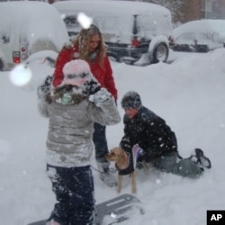 A woman and her children walking their dog and playing in the snow, Fairfax, Virginia, 7 Feb. 2010