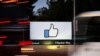 FILE - The entrance sign to Facebook headquarters is seen through two moving buses in Menlo Park, California, Oct. 10, 2018.