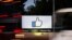 FILE - The entrance sign to Facebook headquarters is seen through two moving buses in Menlo Park, California, Oct. 10, 2018.