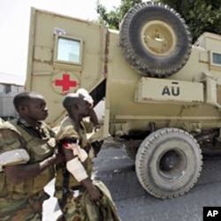 A Ugandan peacekeeper from the African Union Mission in Somalia (AMISOM) assists his wounded colleague after an encounter with Islamist militia in the northern suburbs of Somalia's capital Mogadishu, January 20, 2012