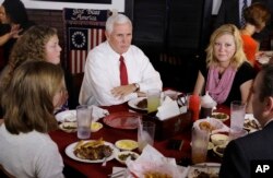 Vice President Mike Pence talks with the McCurry family during a visit to The Pittt Barbecue & Grill, in Anderson, Indiana, Sept. 22, 2017.