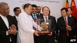 Menteri Pelabuhan dan Perkapalan Sri Lanka Mahinda Samarasinghe (tengah) bertukar hadiah dengan Wakil Presiden Eksekutif China Merchants Port Holdings, Dr. Hu Jianhua, dalam acara penandatanganan perjanjian pelabuhan Hambantota.