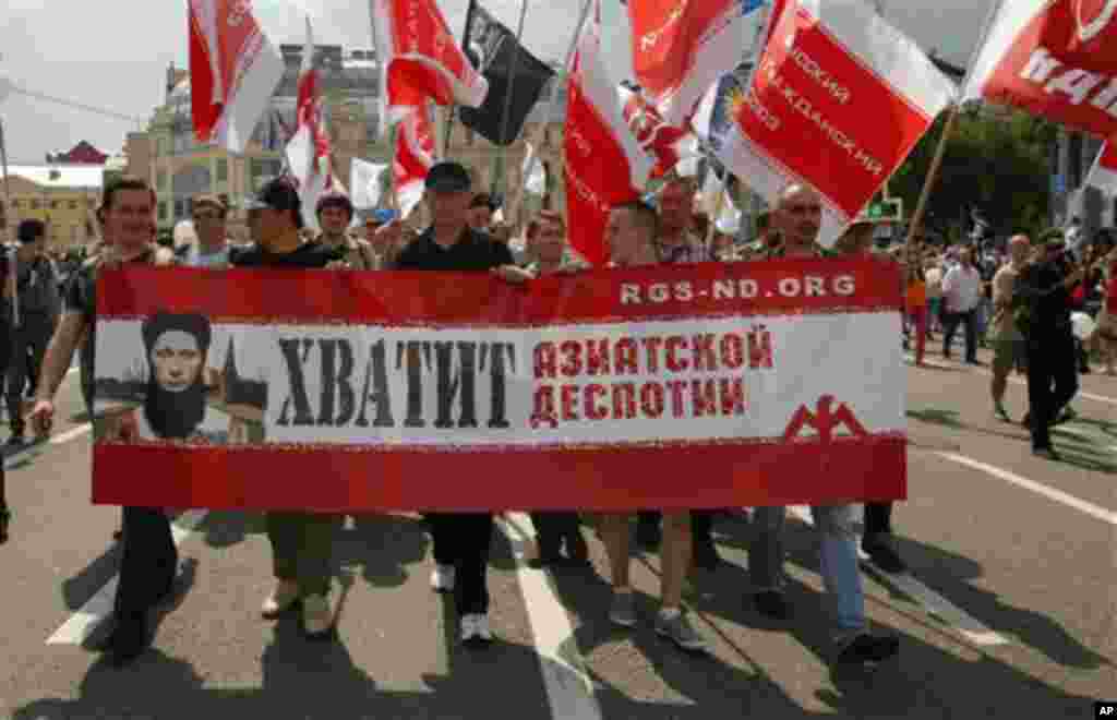 Opposition members march in central Moscow on Tuesday, June 12, 2012m with a poster depicting president Vladimir Putin reading "Enough Asian Despotism". Tens of thousands of Russians flooded Moscow's tree-lined boulevards Tuesday in the first massive pro