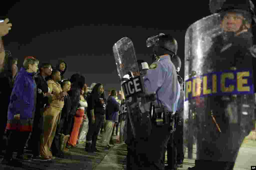 Police and protesters face-off outside the Ferguson Police Department, in Ferguson, March 11, 2015.
