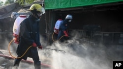 ရန်ကုန်မြို့ရှိ ဈေးတခုတွင် ပိုးသတ်ဆေးများ ဖြန်းနေတဲ့ မီးသတ် ဝန်ထမ်းများ (မတ် ၂၇၊ ၂၀၂၀)