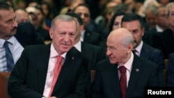 Presiden Turki Tayyip Erdogan (kiri) dan Devlet Bahceli, pemimpin Partai Gerakan Nasionalis (MHP), menghadiri acara Hari Republik untuk memperingati ulang tahun republik ke-101, di Ankara, Turki, 29 Oktober 2024. (Murat Kula/Kantor Pers Kepresidenan/Handout via REUTERS)