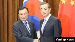 18일 중국을 방문한 한국의 이해찬 중국 특사와 왕이 중국 외교부장이 베이징 외교부에서 만나 악수를 하고 있다.