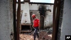 Seorang anggota tim penyelamat menelusuri rumah yang terbakar di daerah Mati, timur Athena, 25 Juli 2018.