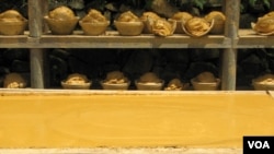 Clay in various stages of drying, on a straw matted frame and in planters.