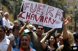 A demonstrator holds up a poster that reads in Spanish: "Get out Chavarry!", referring to Attorney General Pedro Chavarry, in Lima, Peru, Jan. 2, 2019.