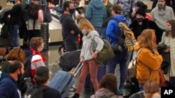 Travelers pass through Salt Lake City International Airport, Jan. 5, 2022, in Salt Lake City. 