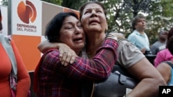 Supporters of Venezuela's President Hugo Chavez weep as she learn that Chavez has died through an announcement by the vice president in Caracas, Venezuela, Tuesday, Mar. 5, 2013.