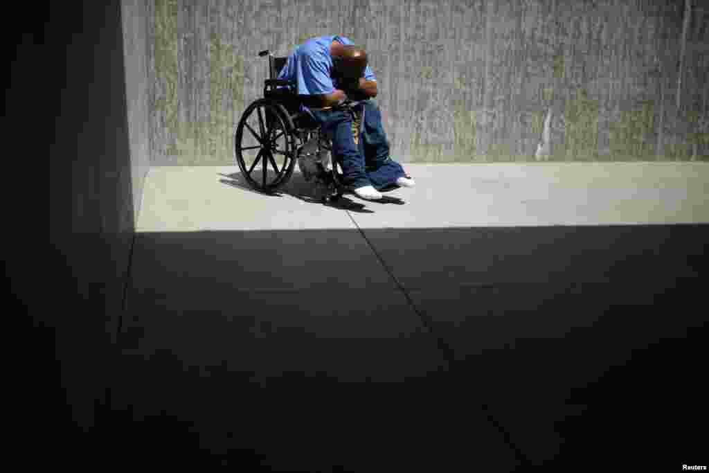 An prisoner sits in the yard of a cell area that mostly houses inmates with cognitive disorders, Alzheimer's, and dementia, at the California Health Care Facility in Stockton, California.