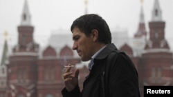 FILE - A man smokes along a street in central Moscow