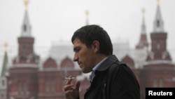 A man smokes along a street in central Moscow, October 16, 2012. 