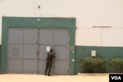 A guard bolts the door of the Thies detention center, one of Senegal's 38 prisons, where almost 30 percent of female convicts are charged with infanticide, in Thies, Senegal, June 1, 2018. (S. Christensen for VOA)