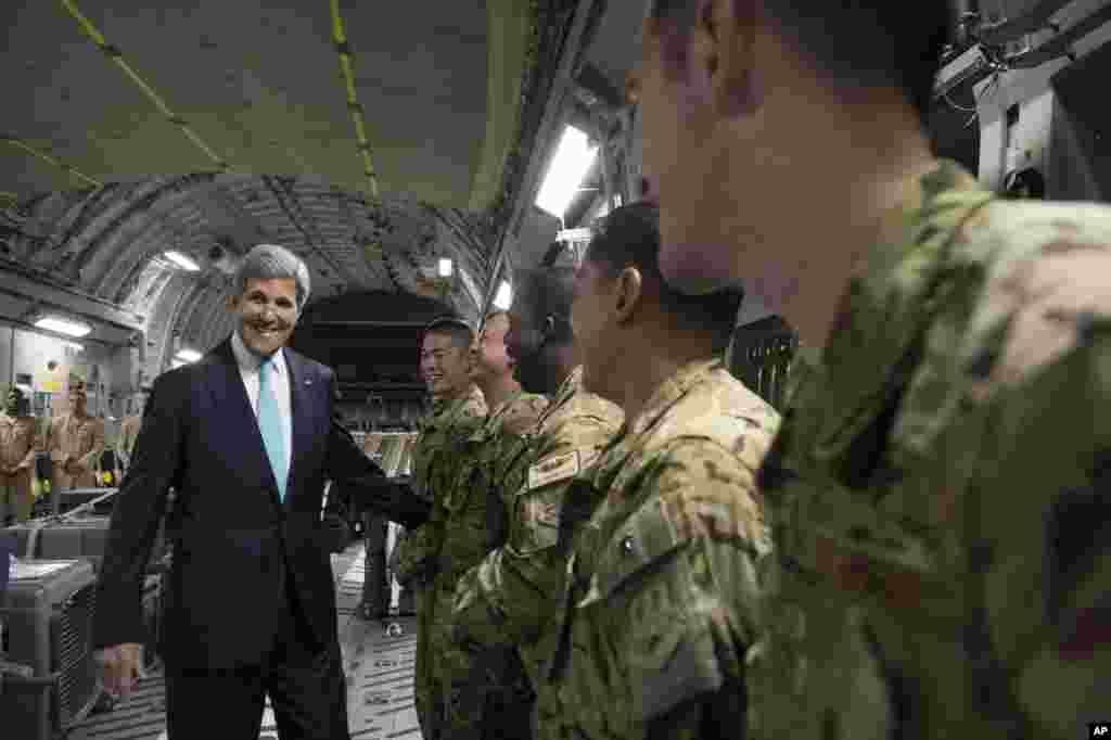 U.S. Sec. of State John Kerry, left, talks with the crew of a U.S. Air Force C-17 military airplane prior to departure from Addis Ababa, Ethiopia, enroute to Juba, South Sudan, May 2, 2014.
