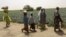 FILE - Women and children walk past fields of Food and Agriculture Organization-supported farms at Jere community, 11 kilometers from Maiduguri, in Borno state, northeast Nigeria, April 6, 2017.