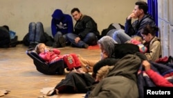 FILE - Kosovars seeking asylum wait in a railway station in Budapest, Feb. 10, 2015. 