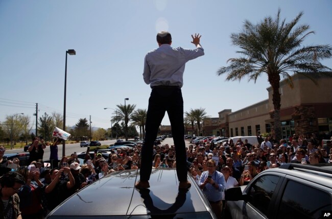 Democratic presidential candidate and former Texas congressman Beto O'Rourke speaks from the roof of his car to an overflow crowd at a campaign stop at a coffee shop Sunday, March 24, 2019, in Las Vegas.