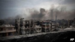 Una nube de humo envuelve el distrito de Saif Al Dawla en Alepo. Siria y Rusia han prometido abrir corredores humanitarios en la asediada ciudad y ofrecer una opción a los combatientes de oposición para que se rindan.