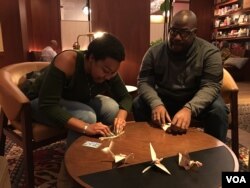 Mya Brown and Dominic Green participate in the 2,300 paper cranes folding event​ at Radical Library inside Eaton DC, Washington DC, on November 18, 2018. (Say Mony/VOA Khmer)